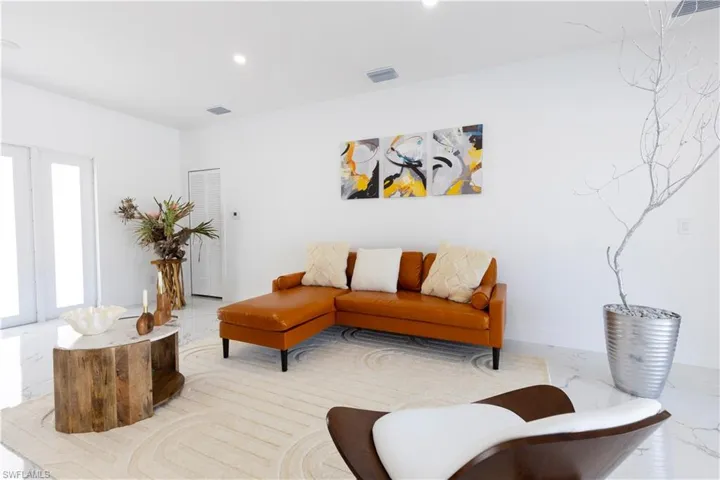 Living room with recessed lighting and light marble finish flooring