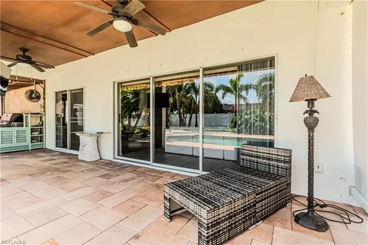 View of patio with ceiling fan and a fenced in pool