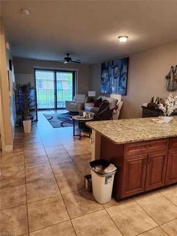 Living room with ceiling fan and light tile patterned floors
