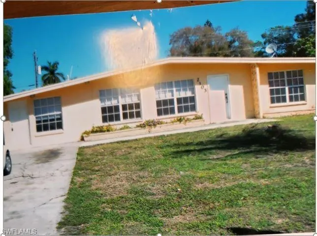 Ranch-style home featuring a front lawn