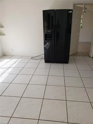 Room details with black fridge and ceiling fan