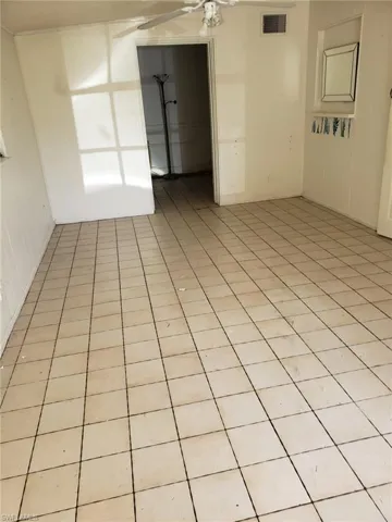 Tiled spare room with ceiling fan