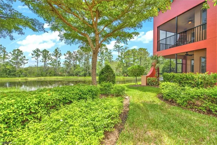 View of yard featuring a balcony, a water view, and ceiling fan