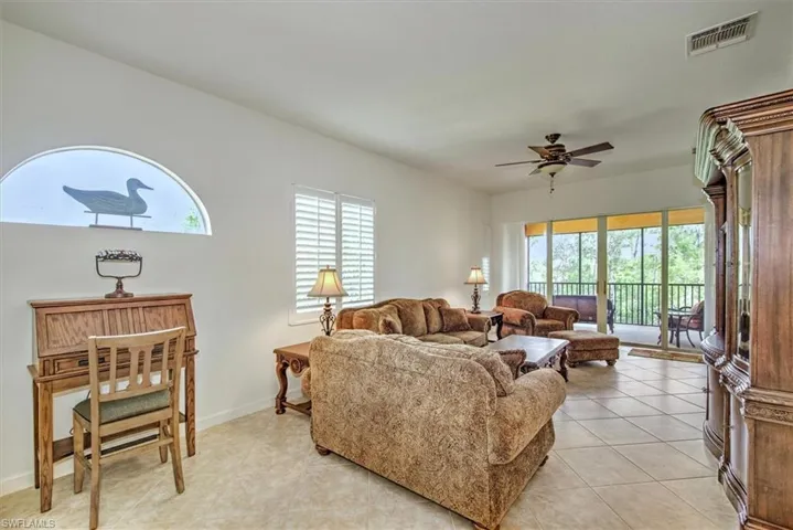 Living room featuring light tile patterned floors and ceiling fan