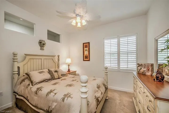 Carpeted bedroom featuring ceiling fan