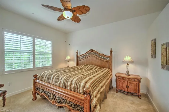 Bedroom with ceiling fan and light colored carpet