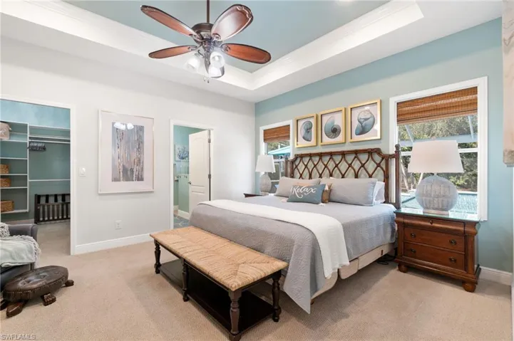 Primary bedroom with tray ceiling and recessed lighting