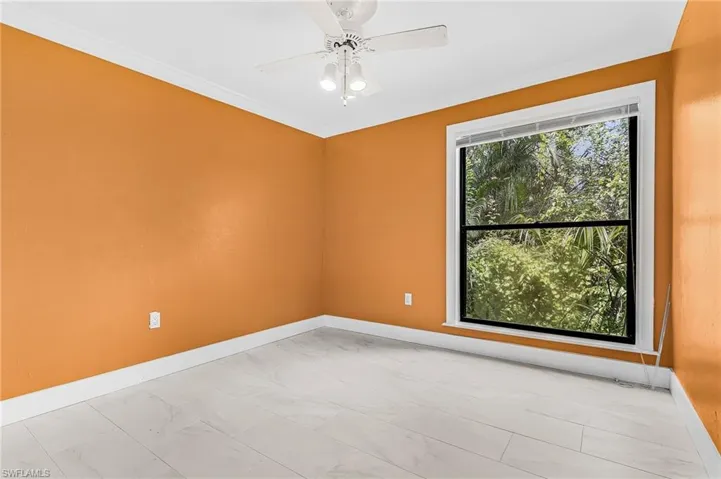 Window with natural surroundings, white crown molding, ceiling fan with integrated lighting, and light-toned flooring