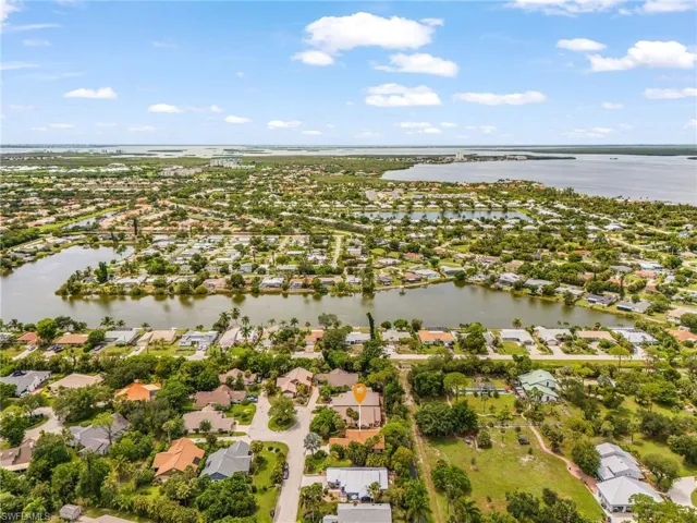 Expansive residential neighborhood featuring numerous properties with water frontage, lush green landscaping, and proximity to large bodies of water