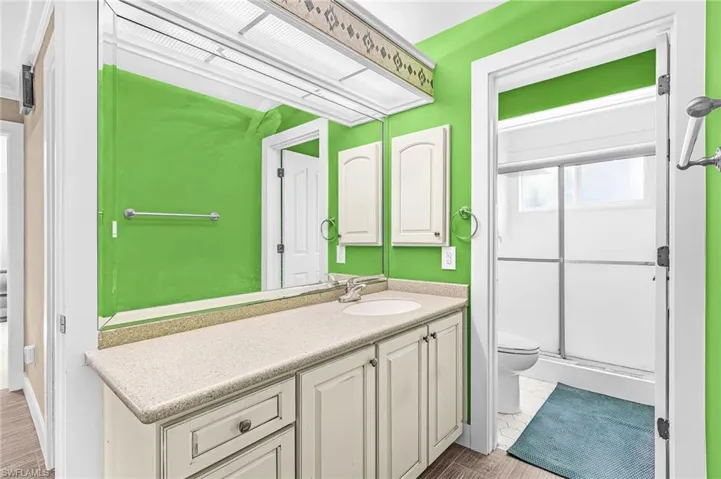 Bathroom vanity with a white basin sink, light-toned countertop, and undermount cabinetry