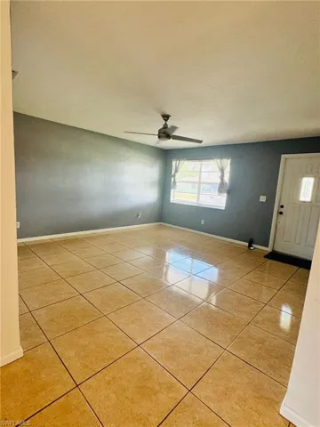 Tiled empty room featuring ceiling fan