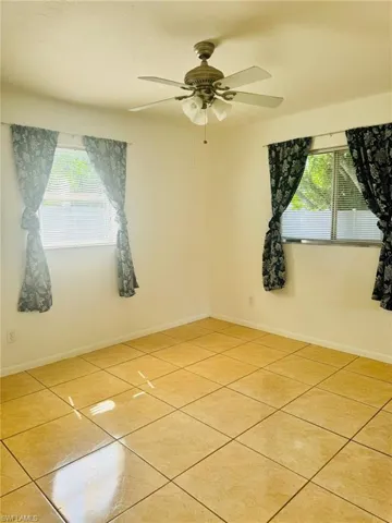 Unfurnished room featuring light tile patterned floors and ceiling fan