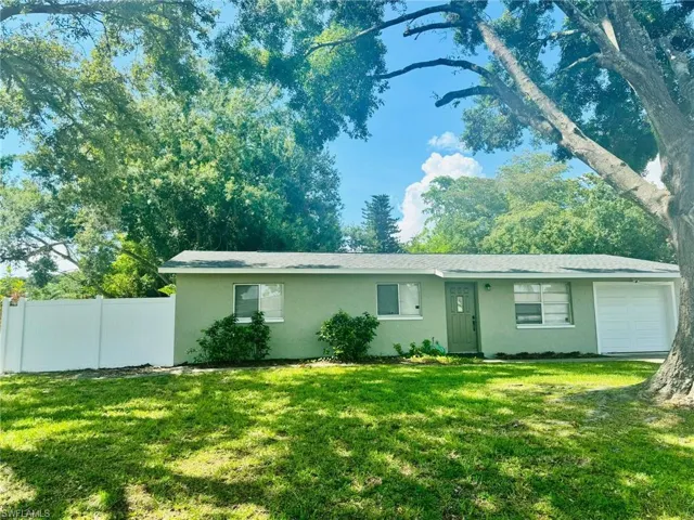 Ranch-style home with a garage and a front lawn