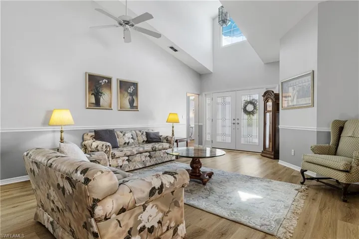 Living area with wood finished floors, french doors, visible vents, and baseboards