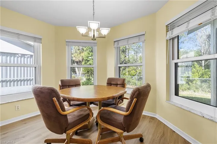Dining room with an inviting chandelier, light wood-style flooring, and baseboards