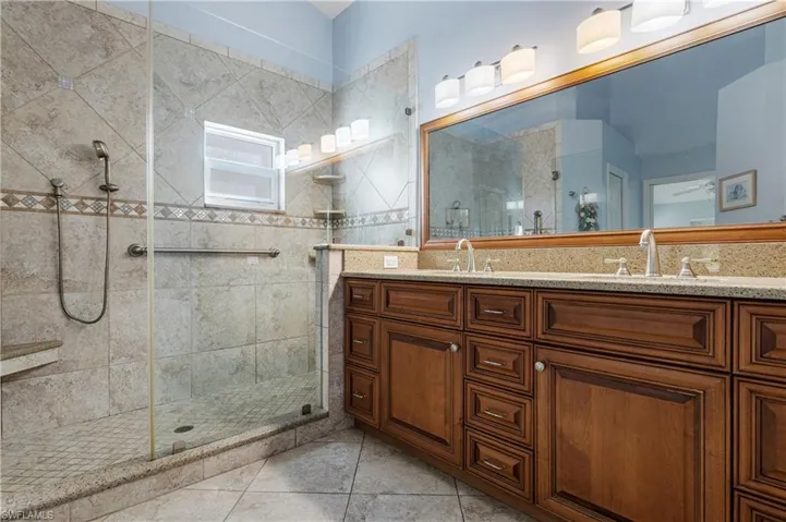 Bathroom featuring vanity, a shower stall, and tile patterned floors