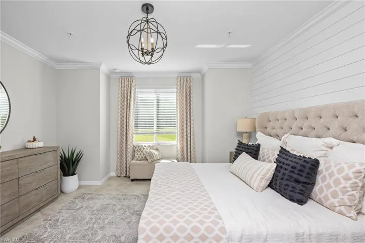 Bedroom with crown molding, light tile patterned floors, baseboards, and a chandelier