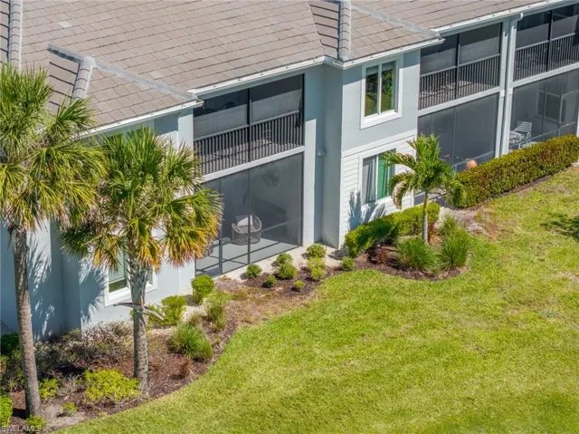 View of side of property featuring a yard, a tile roof, and stucco siding