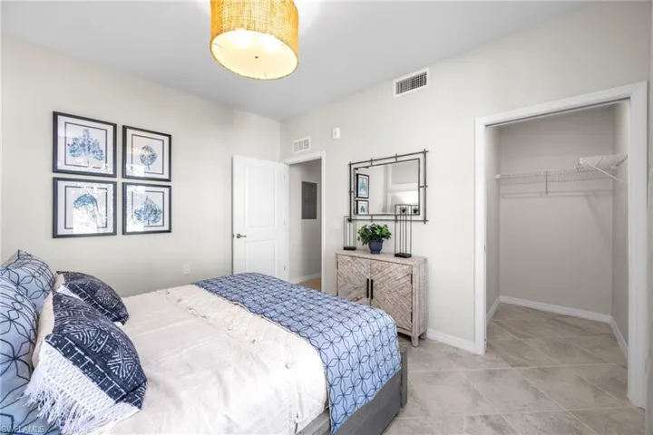 Bedroom with a spacious closet, visible vents, a closet, and baseboards