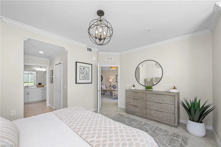 Bedroom with a notable chandelier, visible vents, and ornamental molding