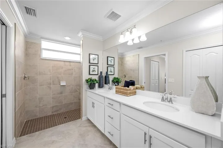 Full bath with walk in shower, visible vents, and a sink