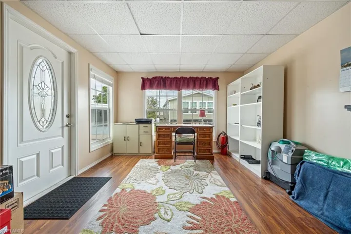 Office with a drop ceiling and wood finished floors