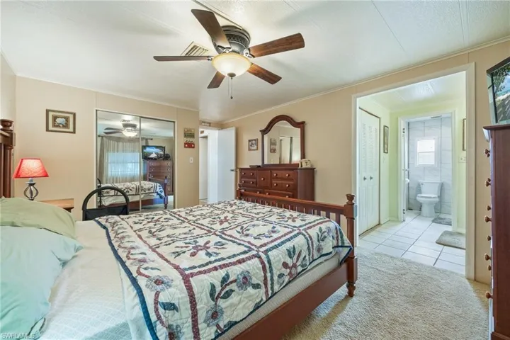 Bedroom featuring tile patterned floors, a closet, a ceiling fan, ornamental molding, and ensuite bath