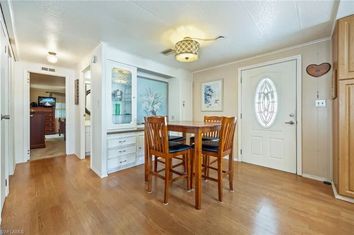 Dining room featuring crown molding, light wood-style floors, and a textured ceiling