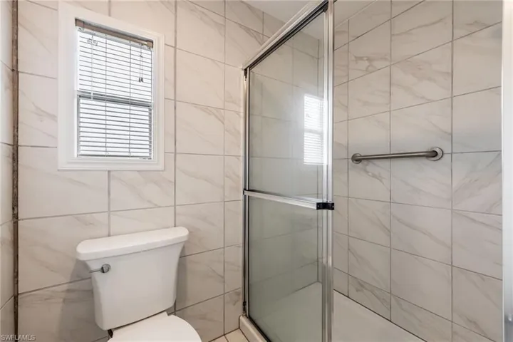 Bathroom with a shower stall and tile walls