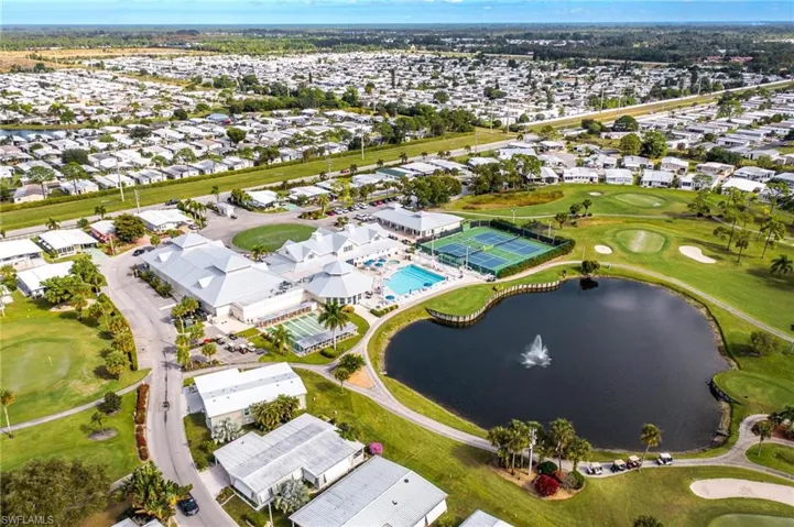 Aerial overview of property's location featuring a golf club, a large body of water, and nearby suburban area