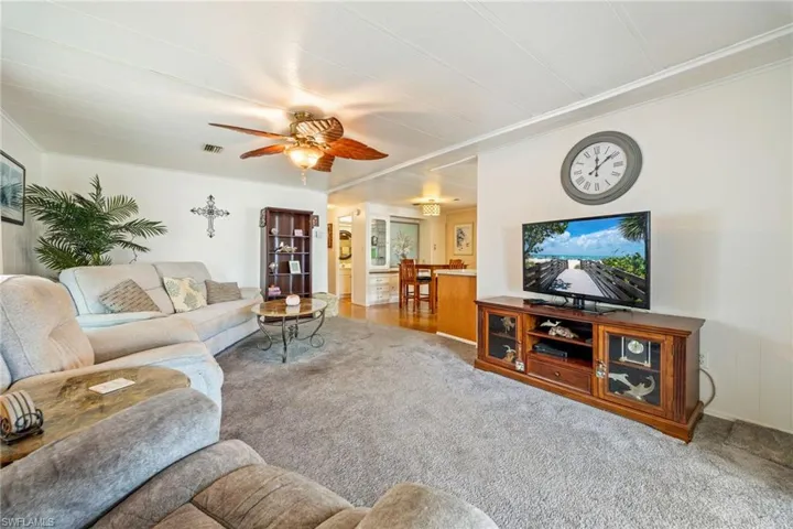 Carpeted living area with ornamental molding