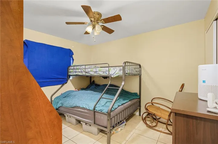 Bedroom featuring light tile patterned floors and ceiling fan
