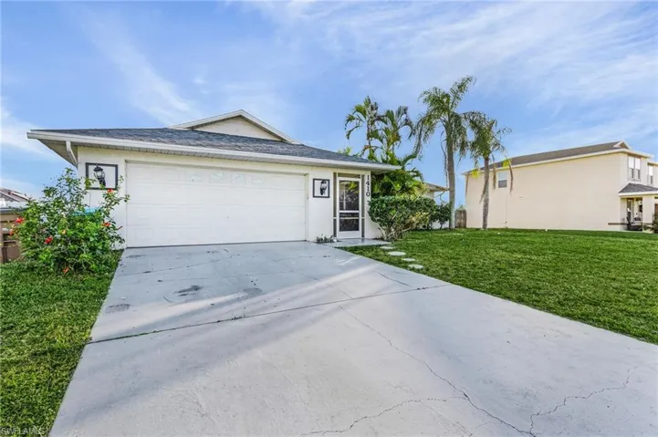 Single story home featuring a garage and a front lawn