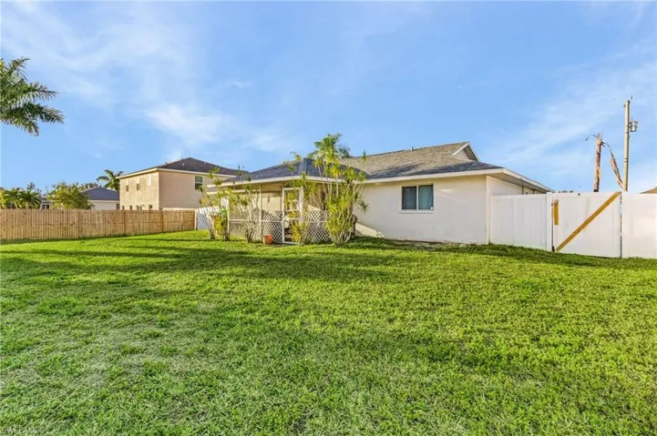 Back of property with a lawn