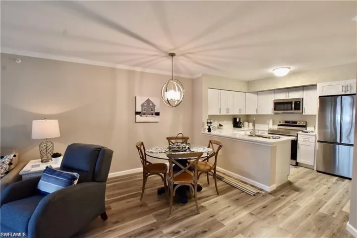 Dining area featuring light wood finished floors, crown molding, and a chandelier