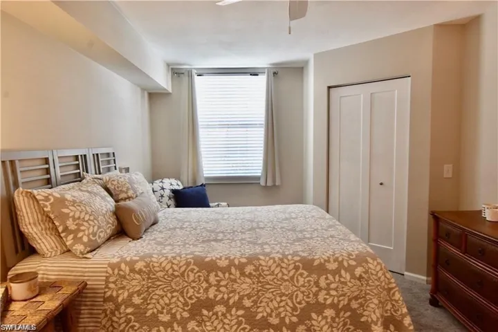 Carpeted bedroom with a closet and ceiling fan