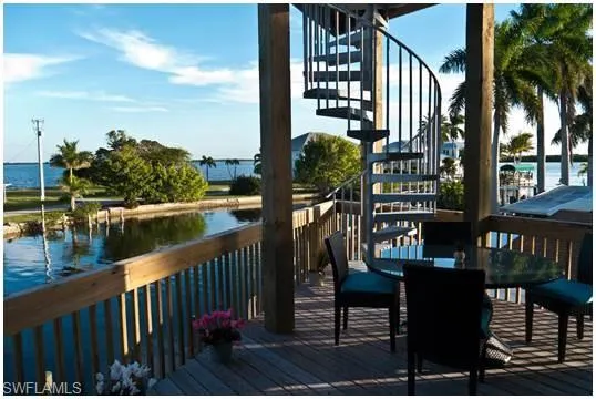 Wooden deck featuring a water view and stairway