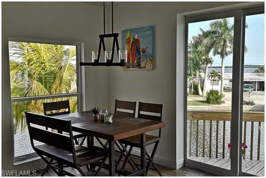 Dining area with healthy amount of natural light, dark wood-type flooring, and a water view