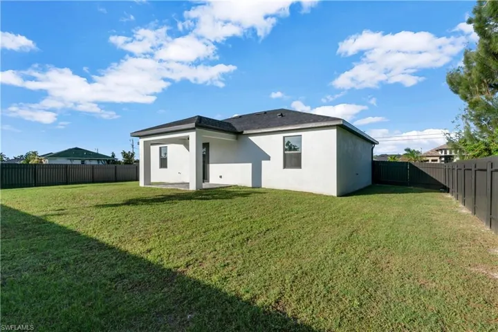 Back of property with a yard and a patio area