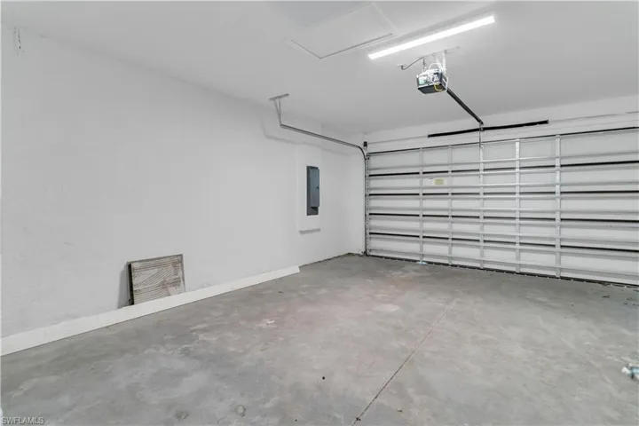 Garage featuring electric panel and a garage door opener