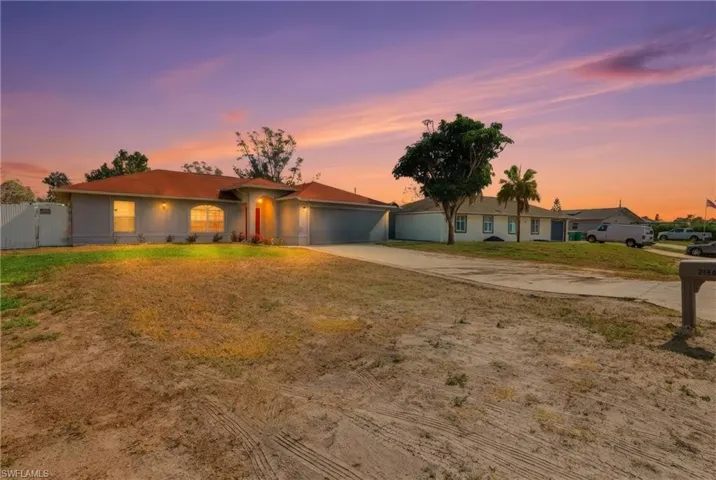 Ranch-style house with driveway, a garage, a gate, and stucco siding