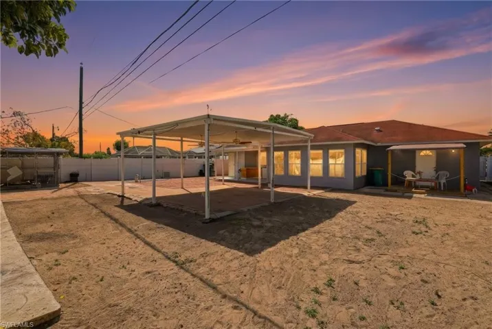 Back of house at dusk featuring a patio and a fenced backyard
