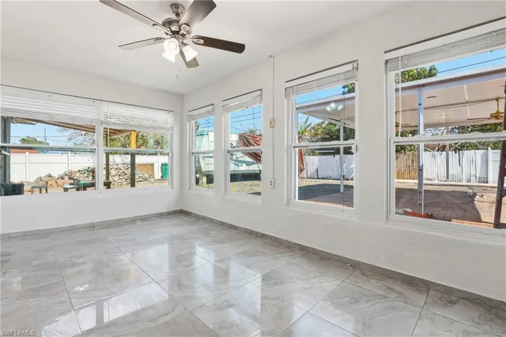 Unfurnished sunroom with baseboards