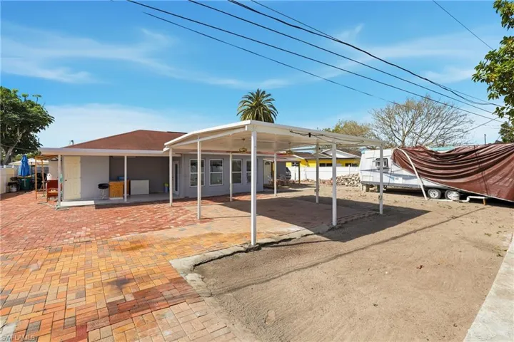 View of parking featuring a ceiling fan and a carport