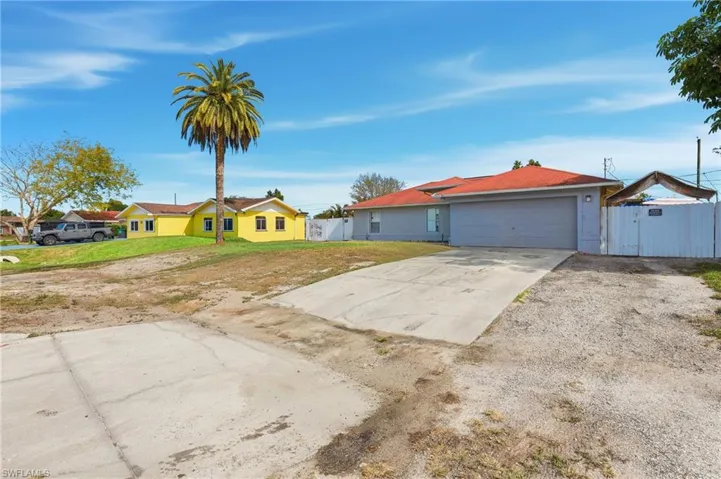 Ranch-style house featuring concrete driveway, a gate, a garage, and a residential view