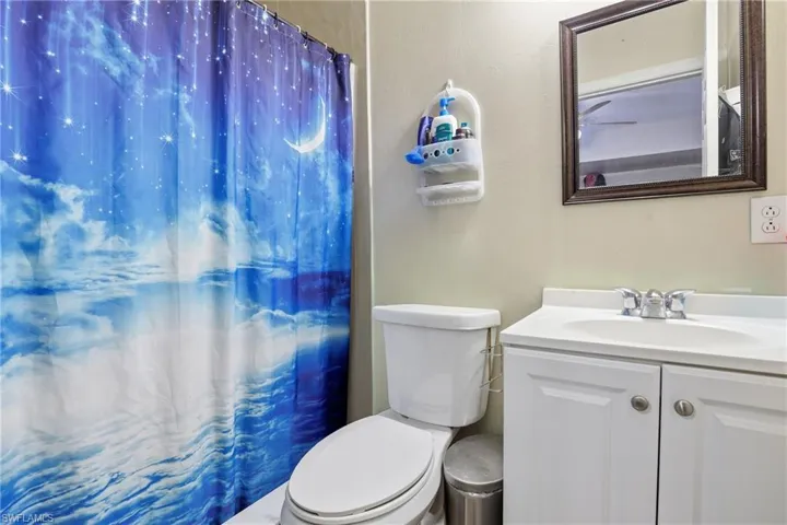Bathroom featuring curtained shower and vanity