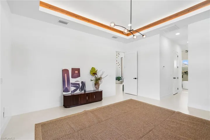 Tray ceiling featuring wood-finish accents and a modern linear chandelier