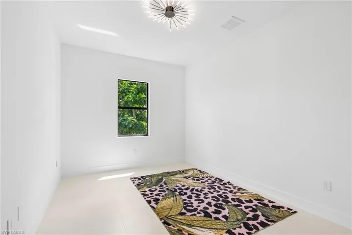 Spacious room featuring a single window, recessed lighting, and a modern ceiling fixture