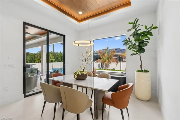 White-tiled interior with a wood-finish ceiling inset featuring a modern linear chandelier