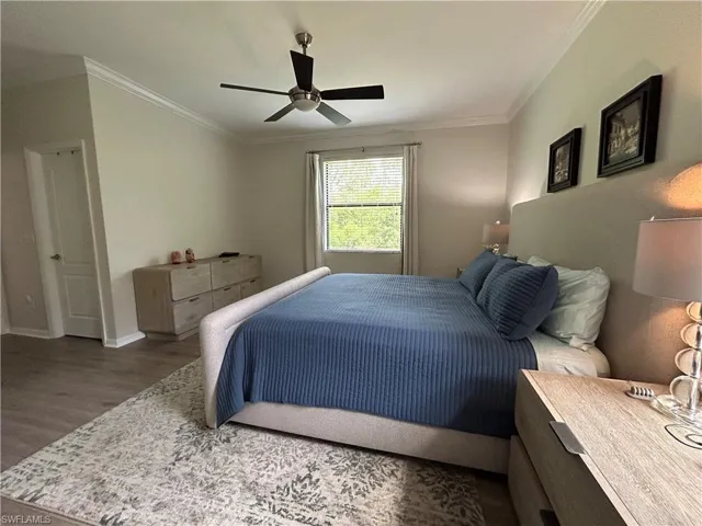 Bedroom featuring crown molding, wood finished floors, and ceiling fan